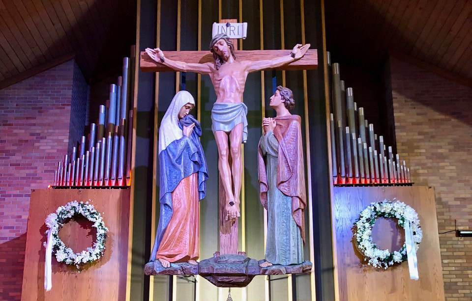 Crucifix flanked by statues and organ pipes in the sanctuary