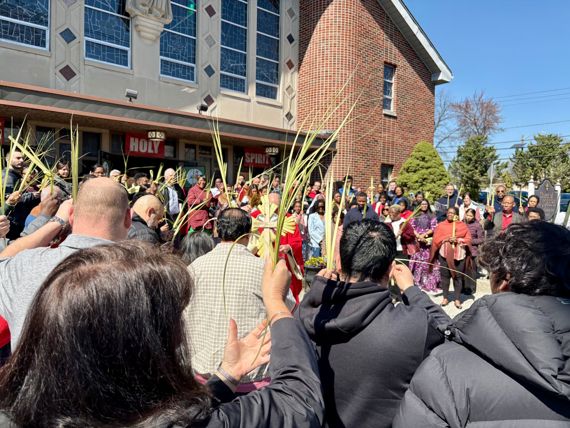 Parishioners holding palms outside the church on Palm Sunday