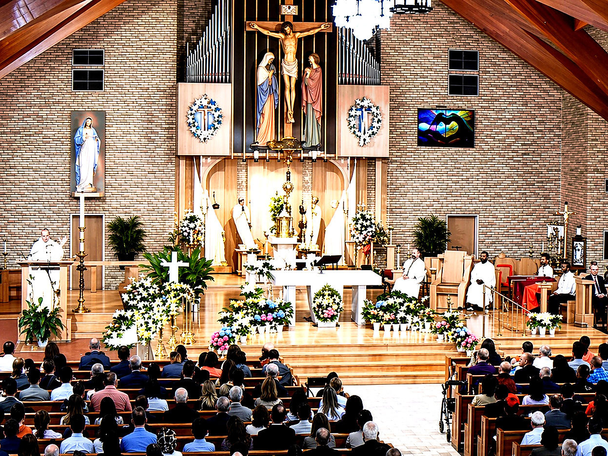 The congregation gathered for a Sunday liturgy, seen from the rear of the church toward the altar dressed with Easter lilies