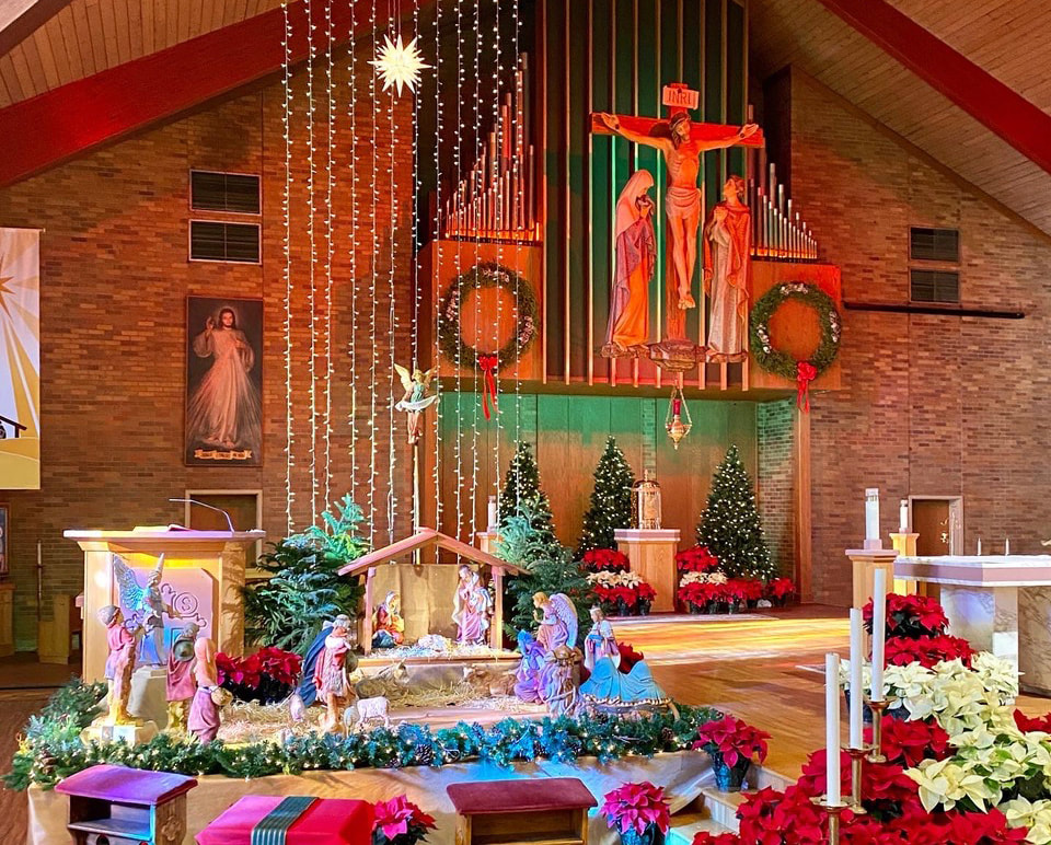 Church interior decorated for Christmas with a nativity scene and poinsettias